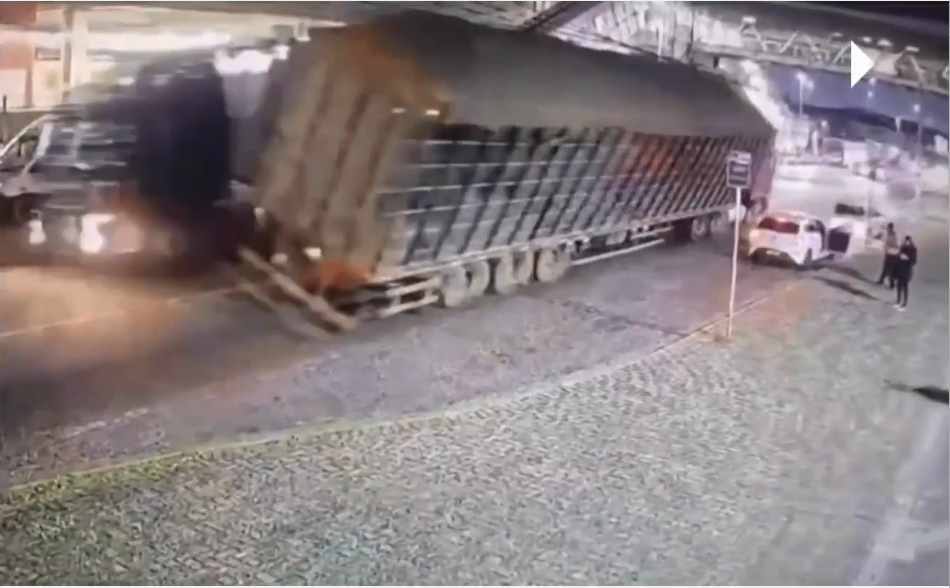 Caminhão carregado de serragem tomba e atinge dois carros