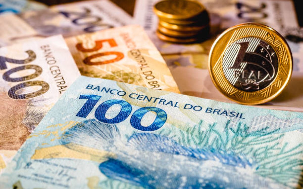 In this photo illustration being displayed one hundred and two hundred reais bills and a one reais coin highlighted. The Real is the current money in Brazil.